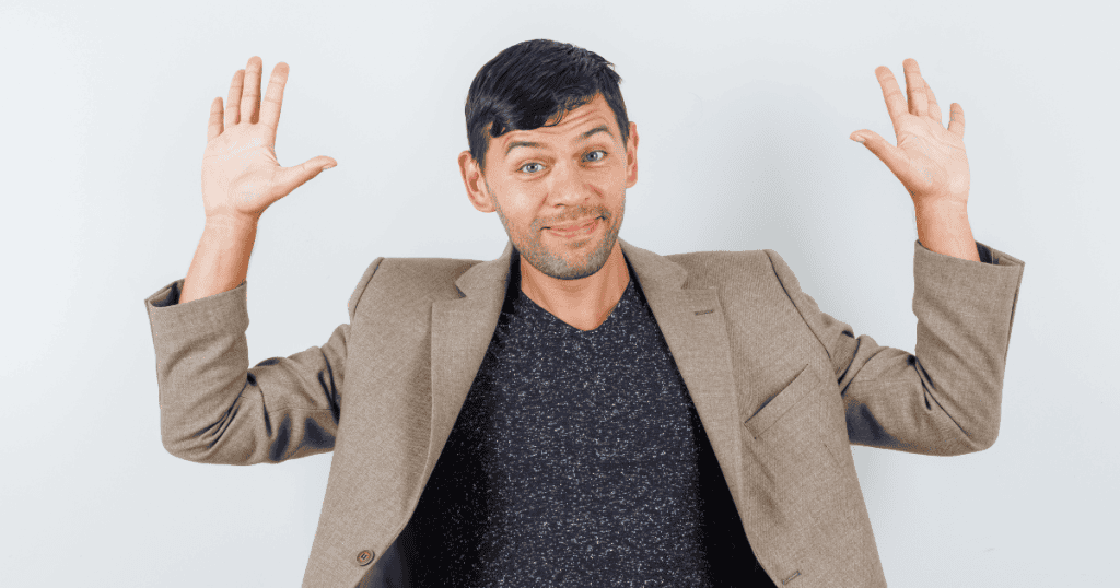 A man in a blazer holds his hands up with a skeptical smirk, signaling a playful yet firm refusal to engage in further games.
