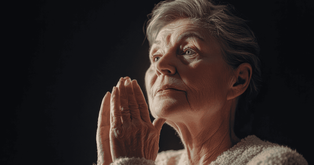An elderly woman looks upward with her hands pressed together in prayer, her pious posture drawing more attention to her own perceived virtue than to any regret.