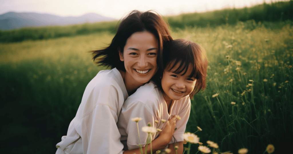 A mother and daughter beam with joy while hugging in a field of wildflowers, representing a bright shift toward a healthier and more affectionate future.