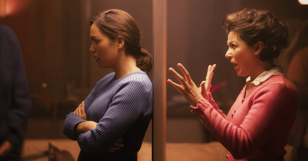 Two women stand back-to-back separated by a wall, illustrating the escalating tension that occurs when one party ceases to validate the other’s self-importance.