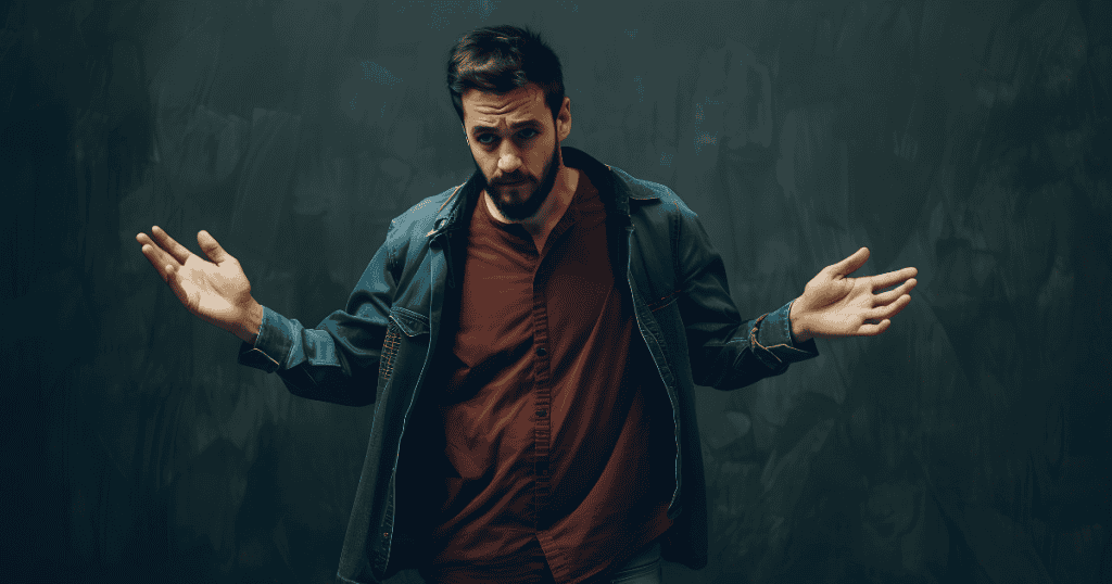 A man stands with his palms up in a submissive shrugging gesture, using non-threatening body language to lower the surrounding tension.