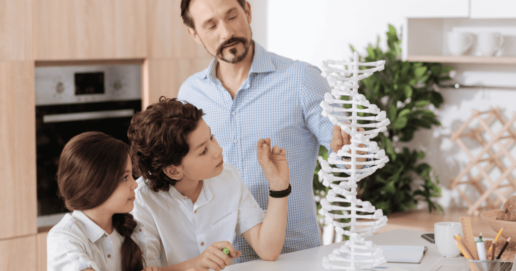 A father demonstrates a DNA double helix model to two attentive children, illustrating how structural blueprints are modeled through observation.