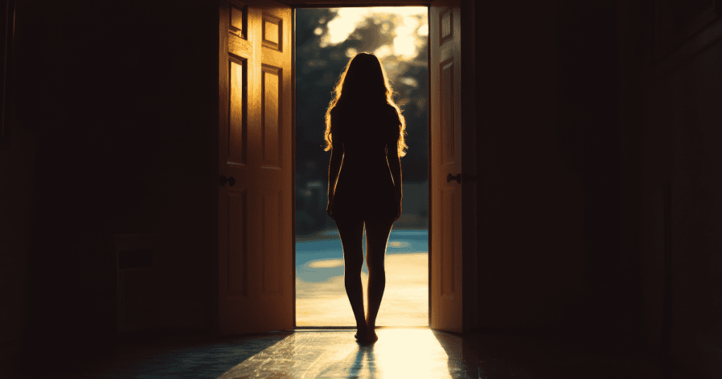 A silhouette of a woman walks toward a doorway flooded with bright golden light, moving away from the shadows and toward a definitive point of release.