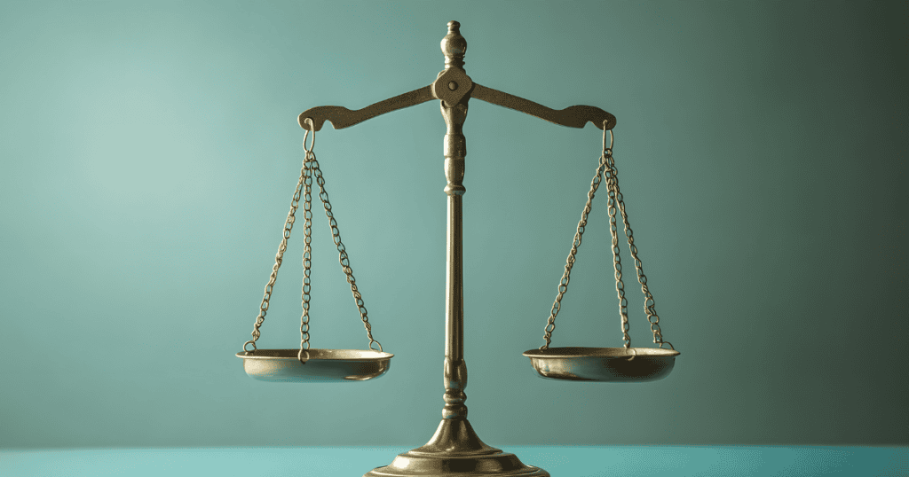 A brass scale of justice sits perfectly balanced against a muted background, representing the careful weight one must give to the consequences of their actions.