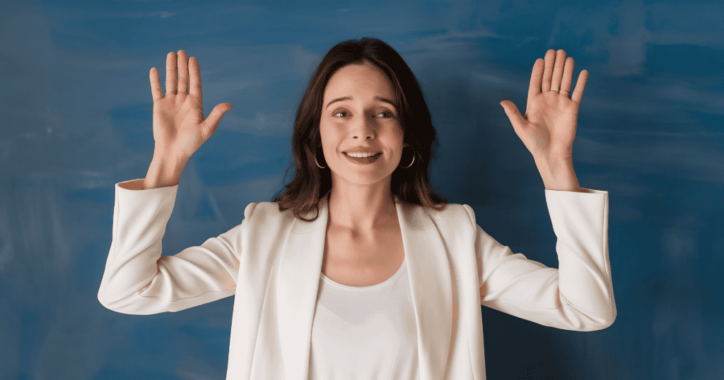 A woman stands confidently with her palms raised forward, signaling a clear boundary between herself and what came before.