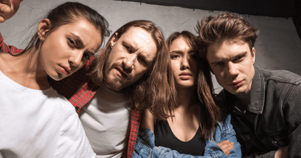 Four young people lean into the camera frame with intense, confrontational stares, capturing the intimidating nature of a group united by a shared, narrow sense of superiority.