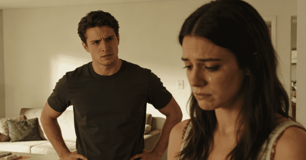 A young woman looks down with a tearful, distressed expression while a man stands with hands on his hips and a tense glare in the background, capturing a heavy emotional climate where internal resilience is tested by persistent psychological pressure.