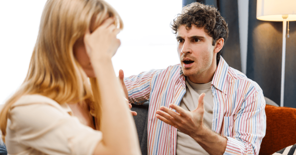 A man speaking aggressively while a woman shields her face in distress, revealing the contempt a narcissistic man struggles to conceal once his mask begins to slip.