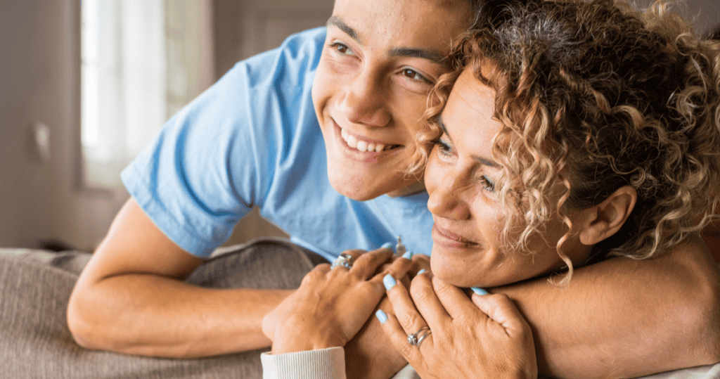A young man smiling warmly beside his mother, showing how a narcissistic man often performs devoted son while treating every other woman in his life with quiet contempt.