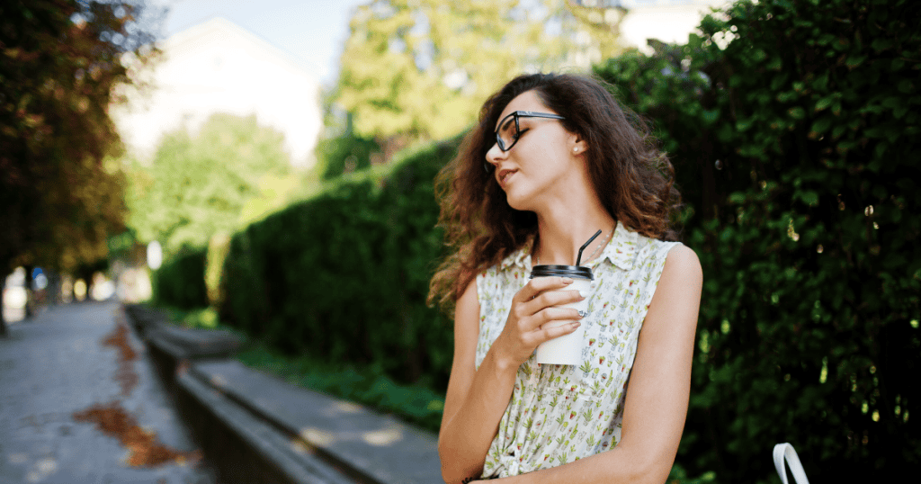 A woman leisurely enjoying her coffee while gazing away, embodying the calm, unbothered energy of someone whose attention is a privilege a narcissist has to earn.