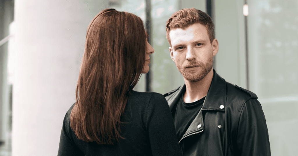 A man staring coldly past a woman standing right beside him, revealing that a narcissistic man's contempt for women isn't tied to any specific place — it's woven into everything he does.