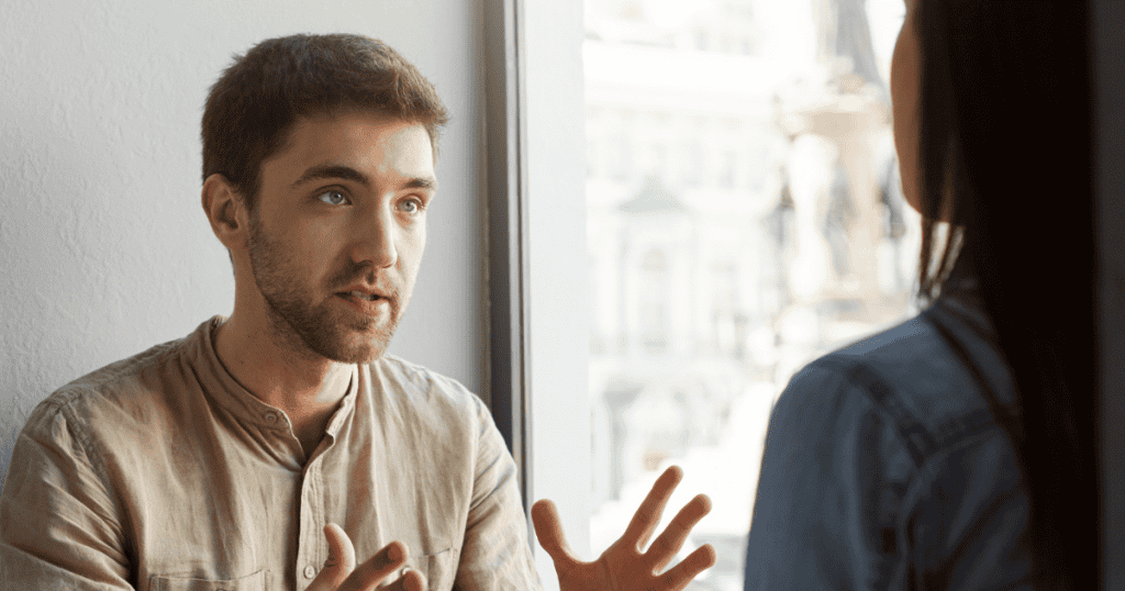 A man speaks with wide, animated hand gestures while looking intently into a woman's eyes, illustrating how passion and conviction can make deceptive claims appear completely sincere.