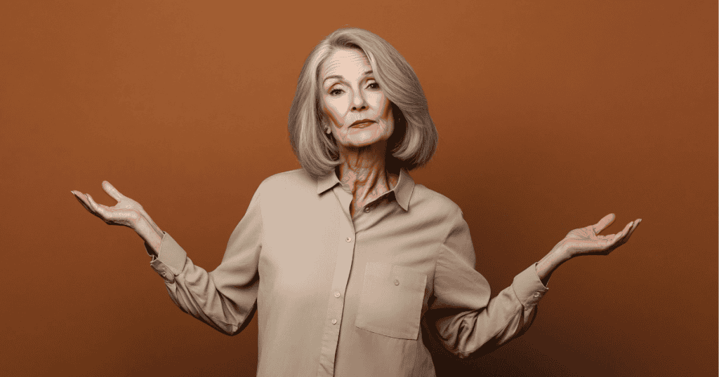 An older woman shrugs with palms turned upward and a skeptical, dismissive expression, embodying the deflection that criticism is simply everyone else being unable to face reality.