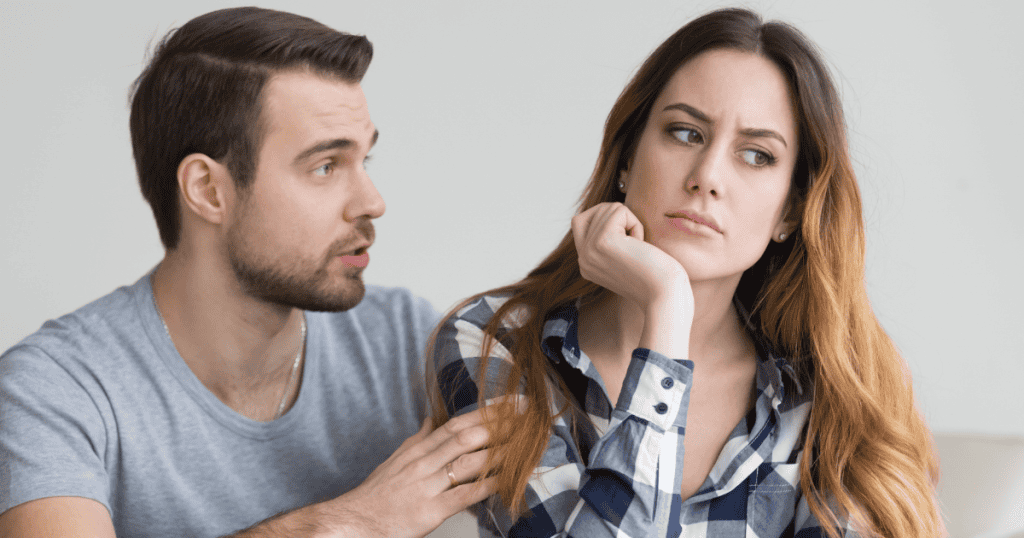 A woman rests her chin on her hand looking away with a weary expression while a man leans in to speak, depicting the quiet exhaustion of hearing endless excuses.