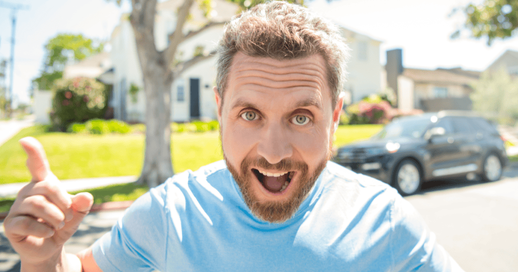 A man with wide eyes and an exaggerated grin points animatedly at the camera outdoors, capturing the theatrical over-the-top energy behind the claim that all his exes are "crazy."