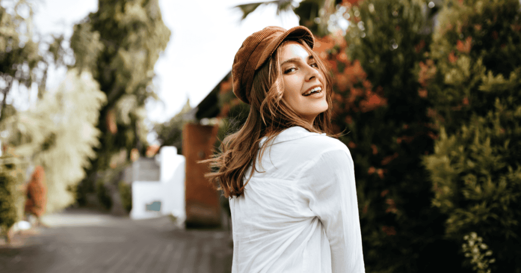 A woman glancing back with a radiant smile, embodying the unshakeable self-worth a narcissist's humiliation ultimately forces you to discover deep within yourself.