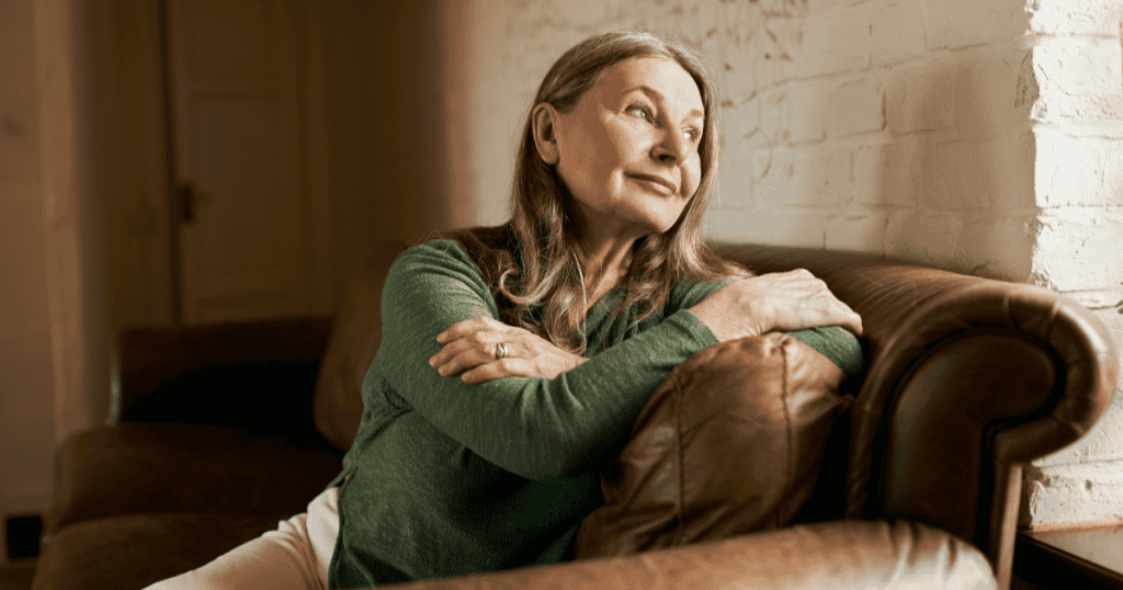 A woman sits with a smug, self-satisfied smile while gazing off to the side, her calm composure hinting at the manipulative deflection that follows the harm she's caused.