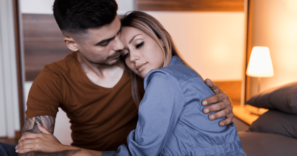 A woman rests her head on a man's shoulder with her eyes closed as he holds her close, showing how the comfort and closeness a narcissist offers can feel so safe that you miss the warning signs.