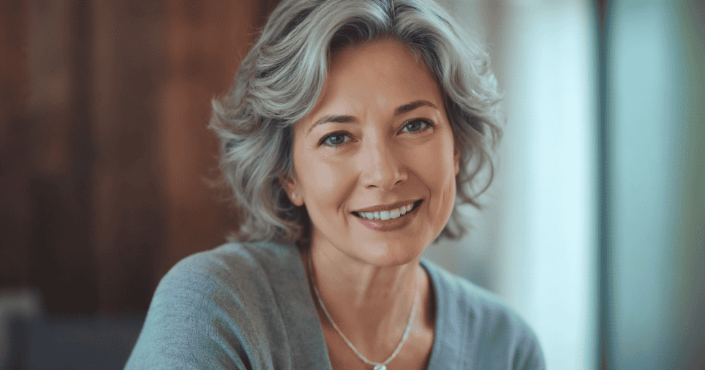A silver-haired woman smiles with quiet self-satisfaction, reflecting how a narcissist tells others you’re obsessed with them to paint you as fixated while making themselves look desirable.