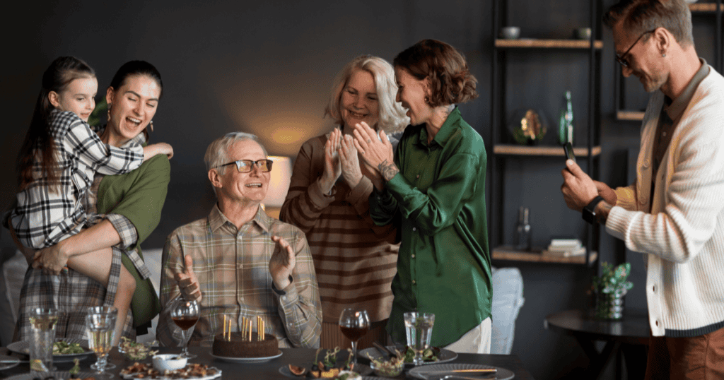 A family gathers around a birthday cake, clapping and laughing together, showing the open, welcoming embrace of loved ones that the right partner gladly invites you into.